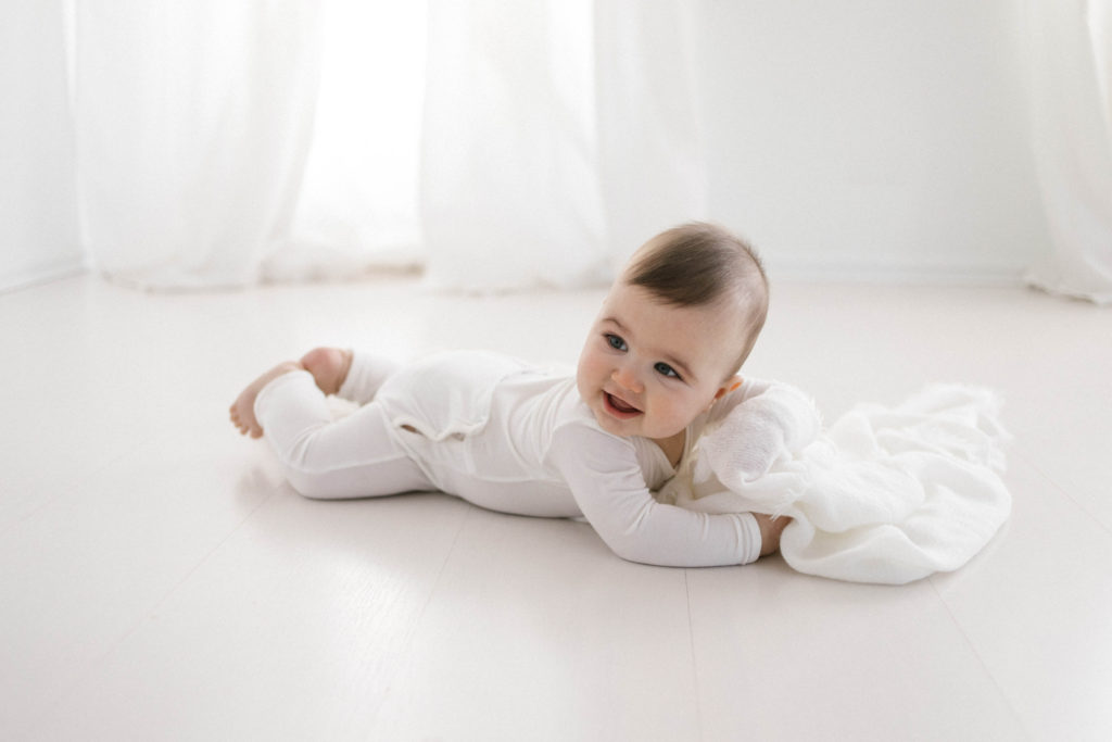 Six Month Milestone Sessions including a gorgeous baby boy in a cotton onsie and photographed in a beautiful white studio space in Chicago IL