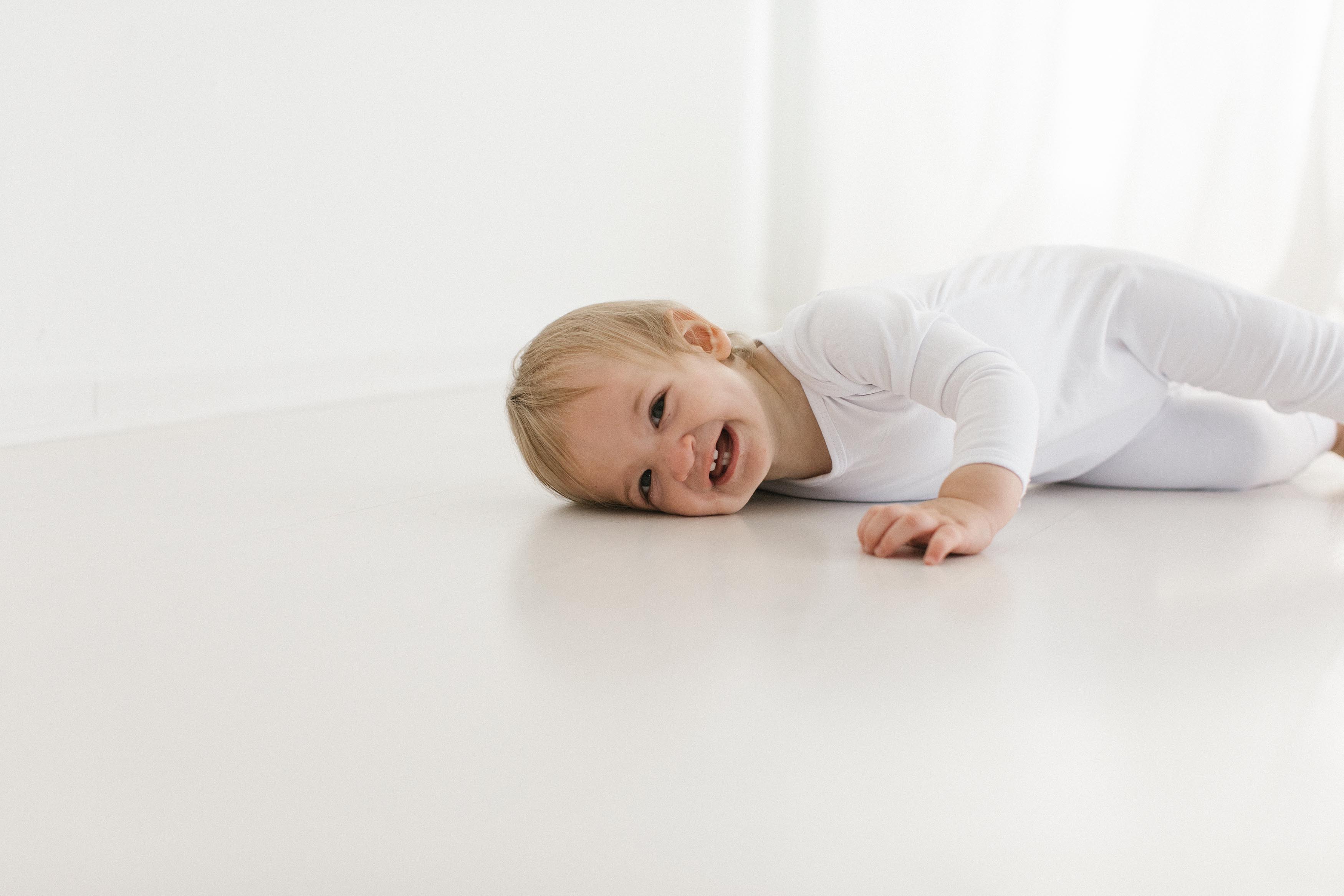 Elle Baker Photography captures baby in white studio with white outfit on
