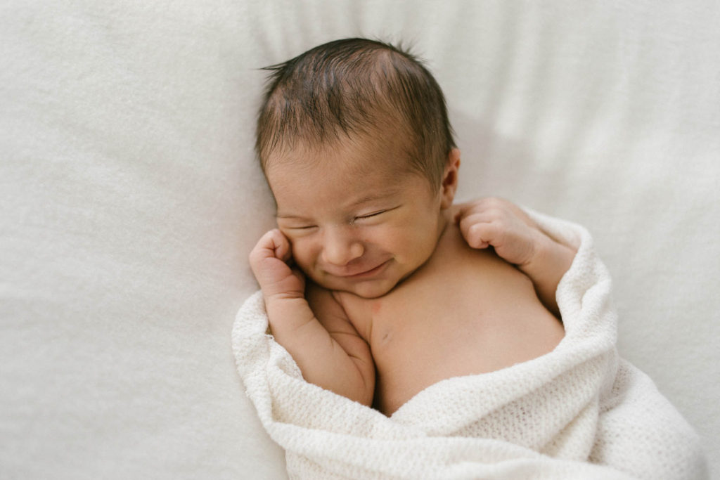 Homer Glen, IL newborn photography studio, Photo by Elle Baker Photography, newborn smiling in white wrap in a white studio