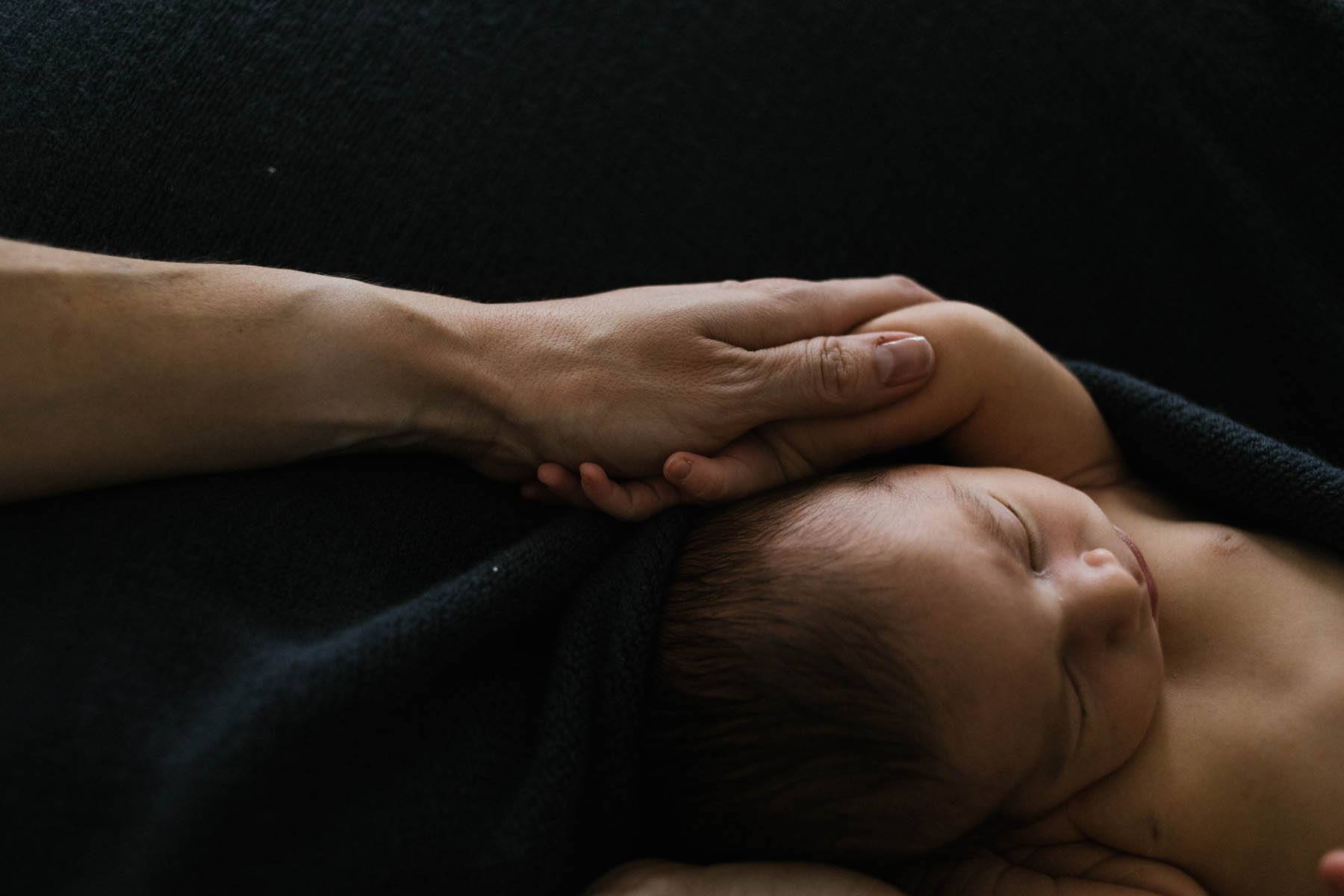 Newborn Photographer in Chicago | Photo by Elle Baker Photography | Mother holding her newborns hand | Simple newborn posing ideas