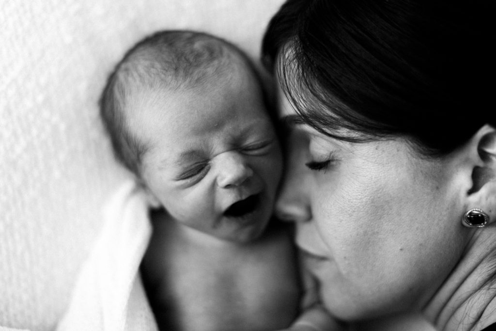 Chicago Pregnancy and Newborn Photographer, Photo by Elle Baker Photography, black and white image of newborn yawning and mother snuggling him