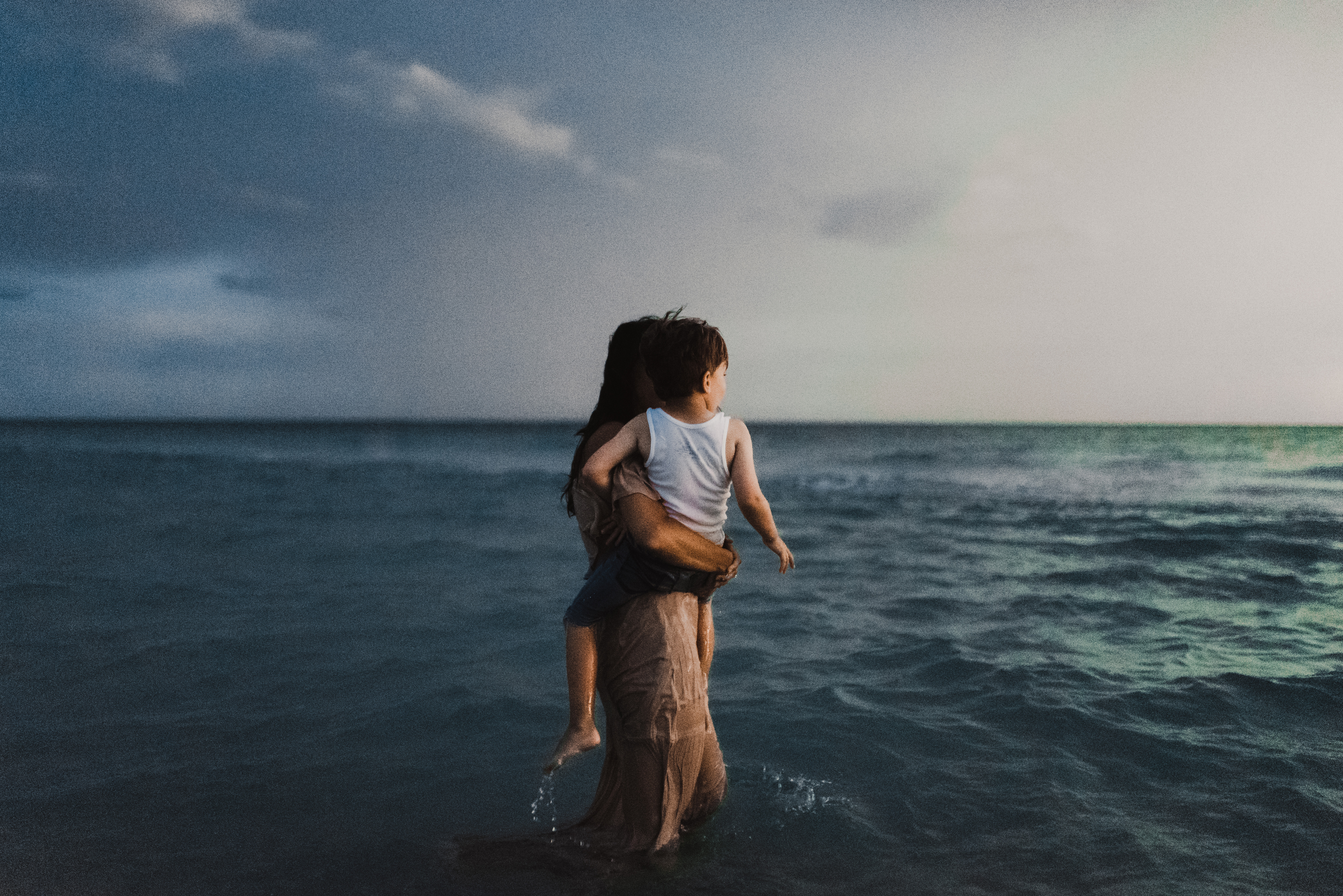 Family Photographer in Chicago, IL, Photo by Elle Baker Photography, Laurie Baker carries son into ocean