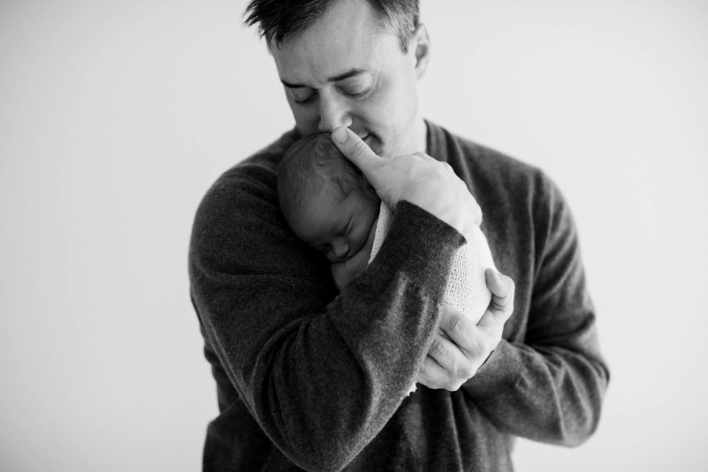 father holding newborn baby at Laurie Baker's Chicago newborn photography studio