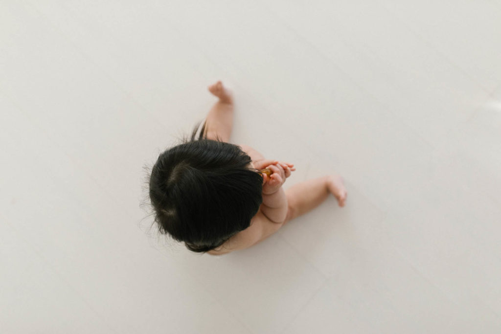 overhead photo of a baby girl with dark hair 