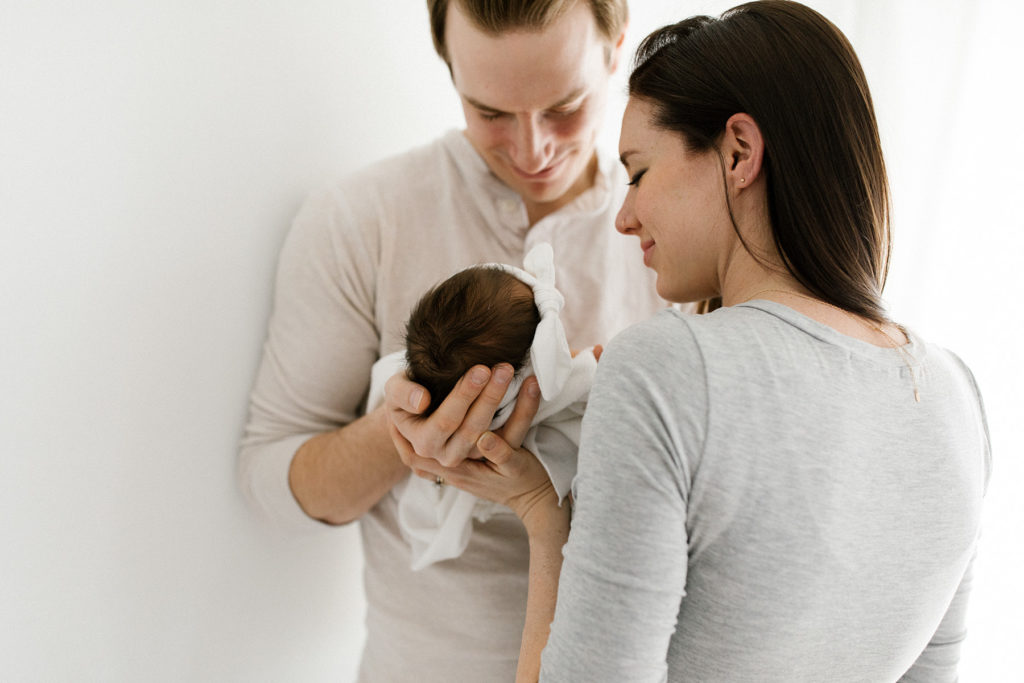 parents holding newborn baby 