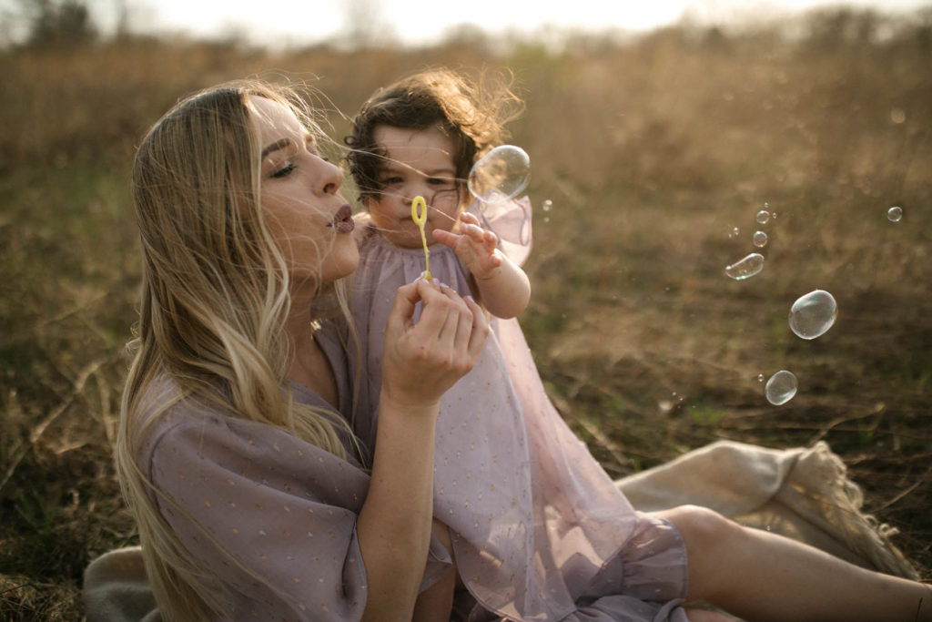 Elle Baker Photography captures mom blowing bubbles with her baby at Chicago family portraits 