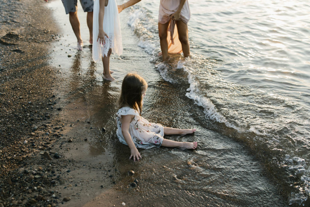 family of four playing in the sand during a beach sunset session with Elle Baker Photography 