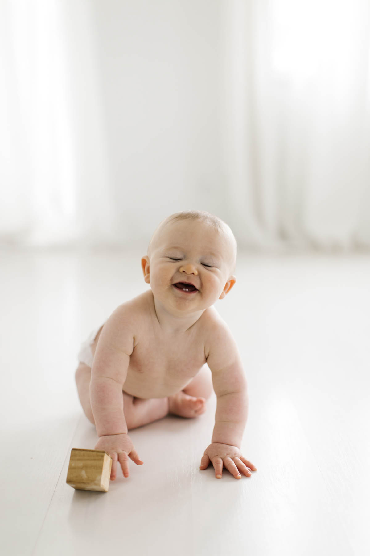 six month milestone session with baby boy laughing 