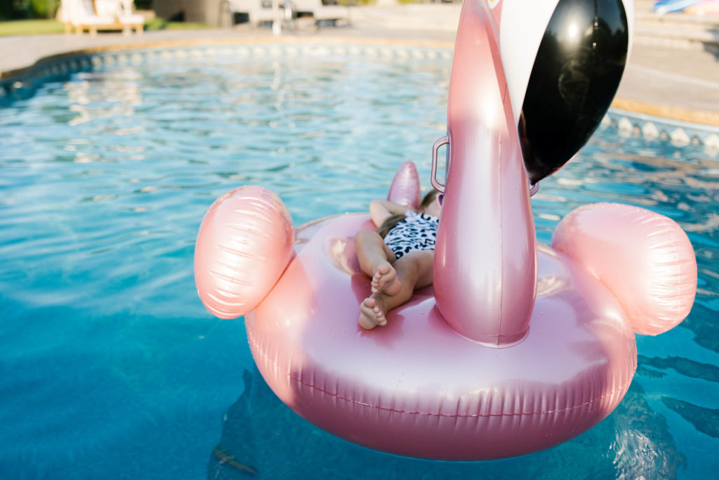 little girl floating on a raft in a pool during Frankfort lifestyle session 