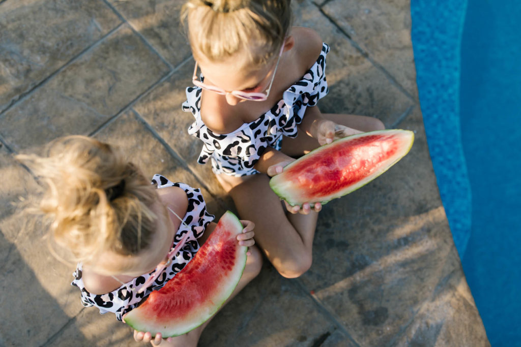 two girls eating watermelon during summer session 