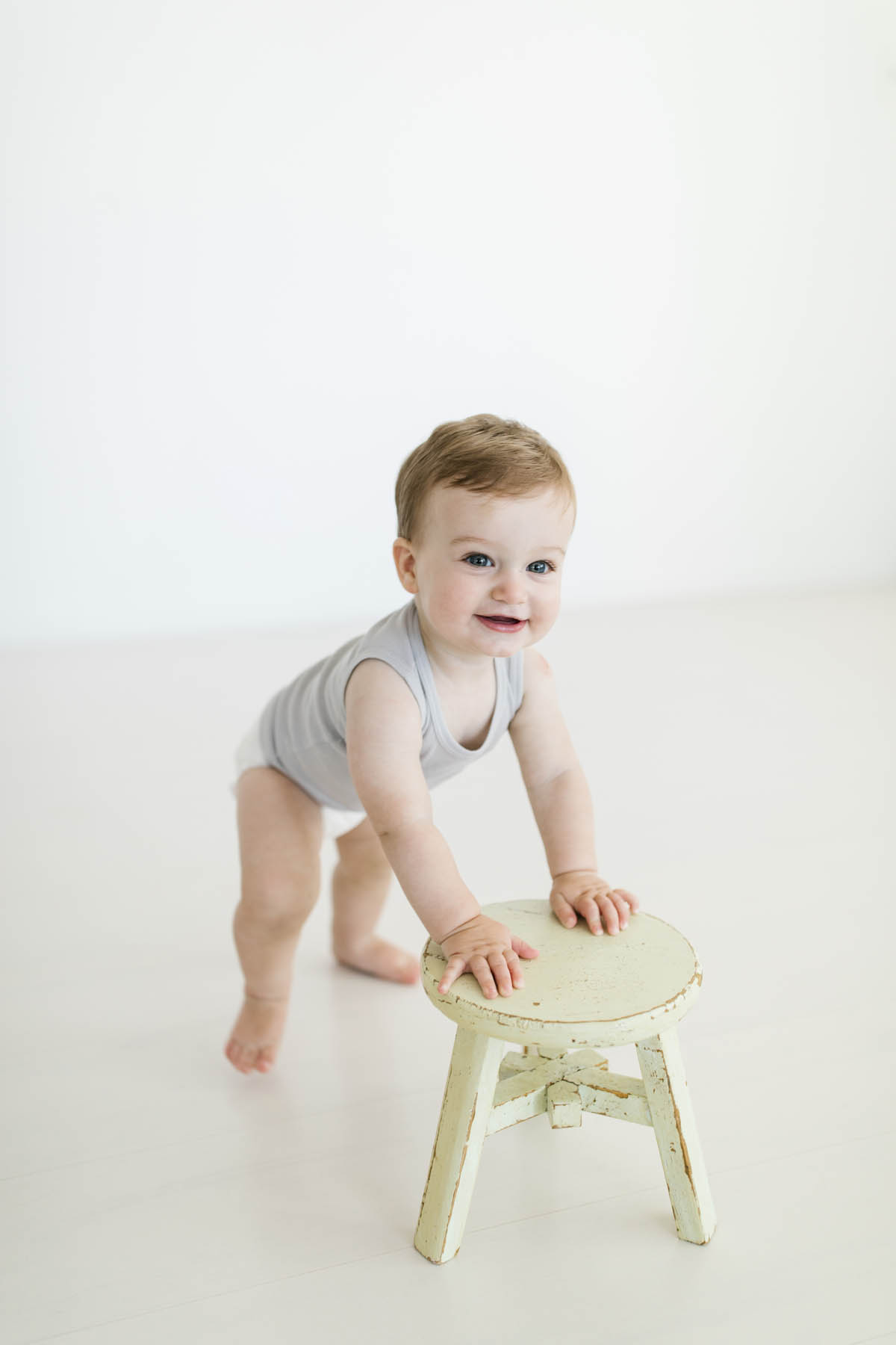 baby boy pushing a stool during photo shoot 