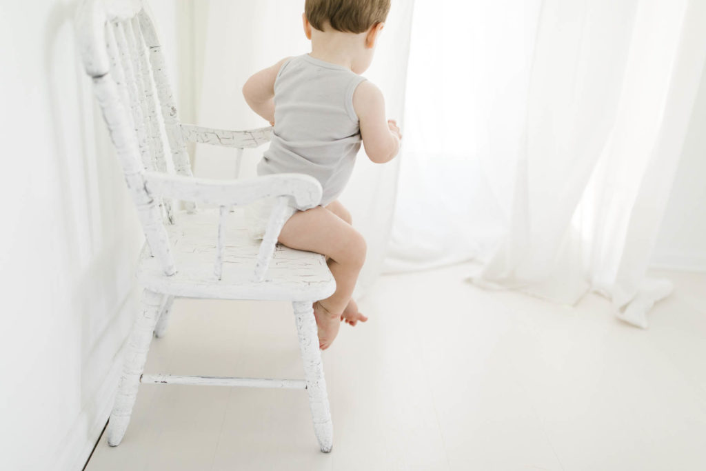 baby climbing down off of a chair 