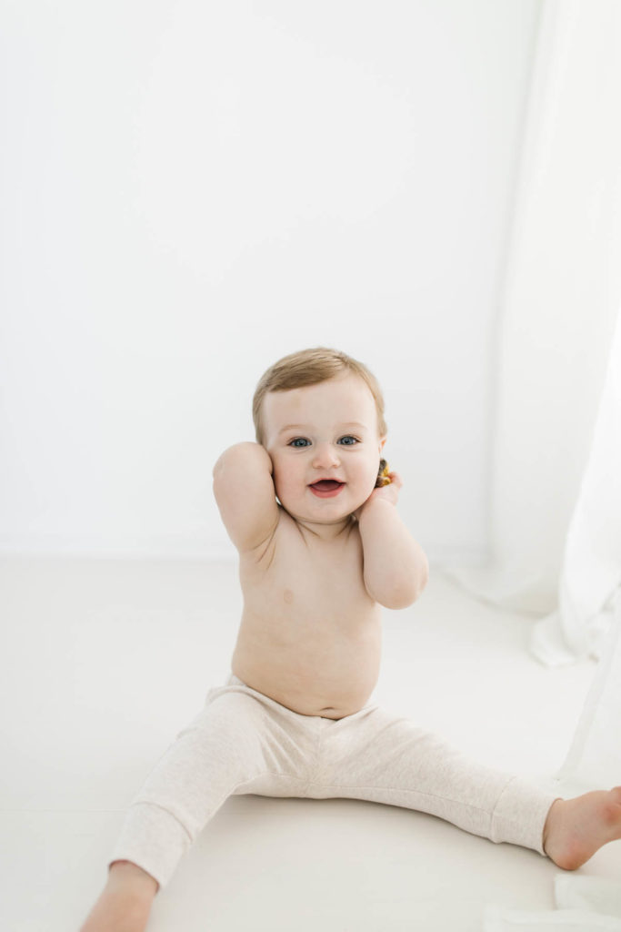 little baby sitting on white studio during baby's first year plan session 