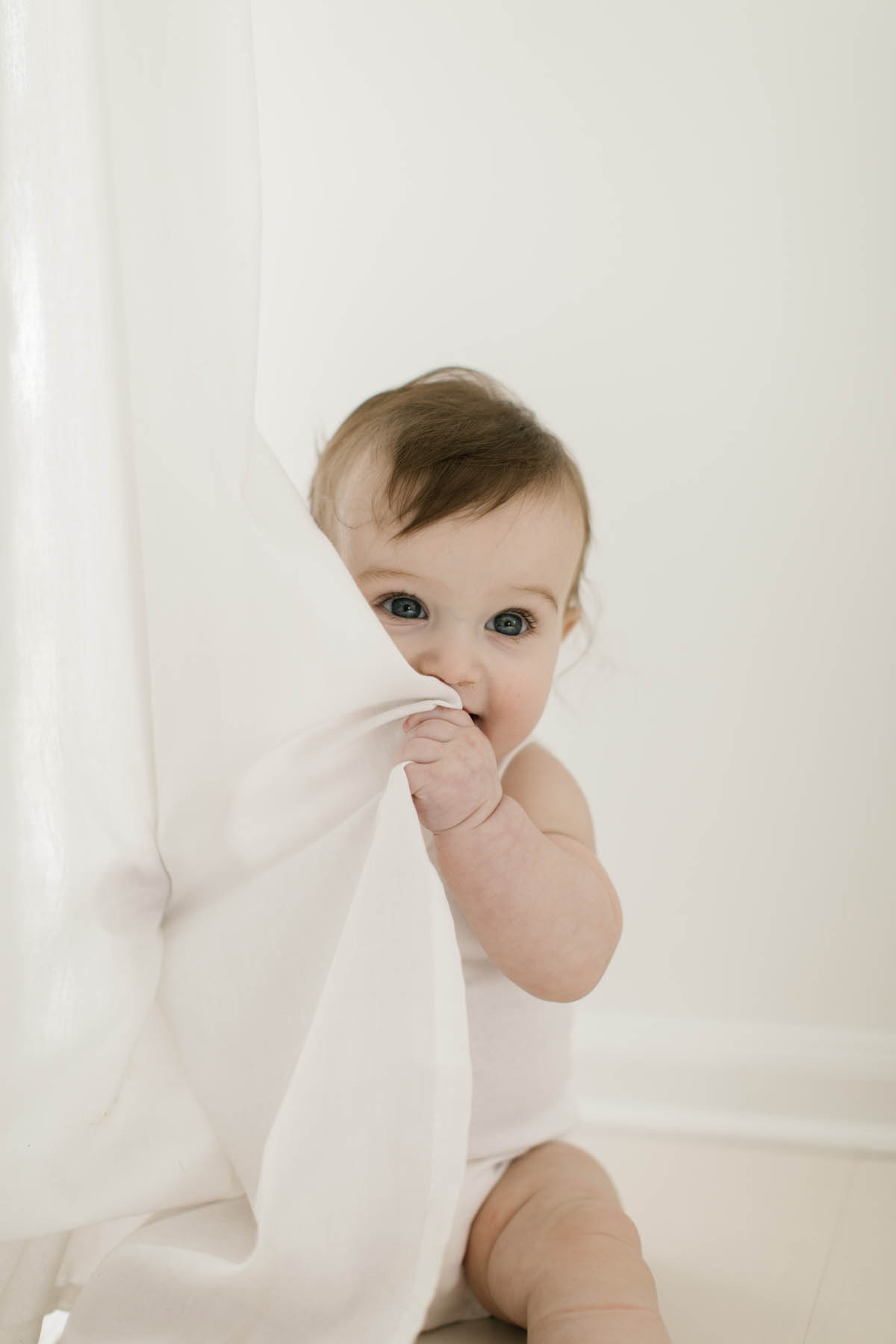 baby boy chews on white curtains at Homer Glen, IL studio 
