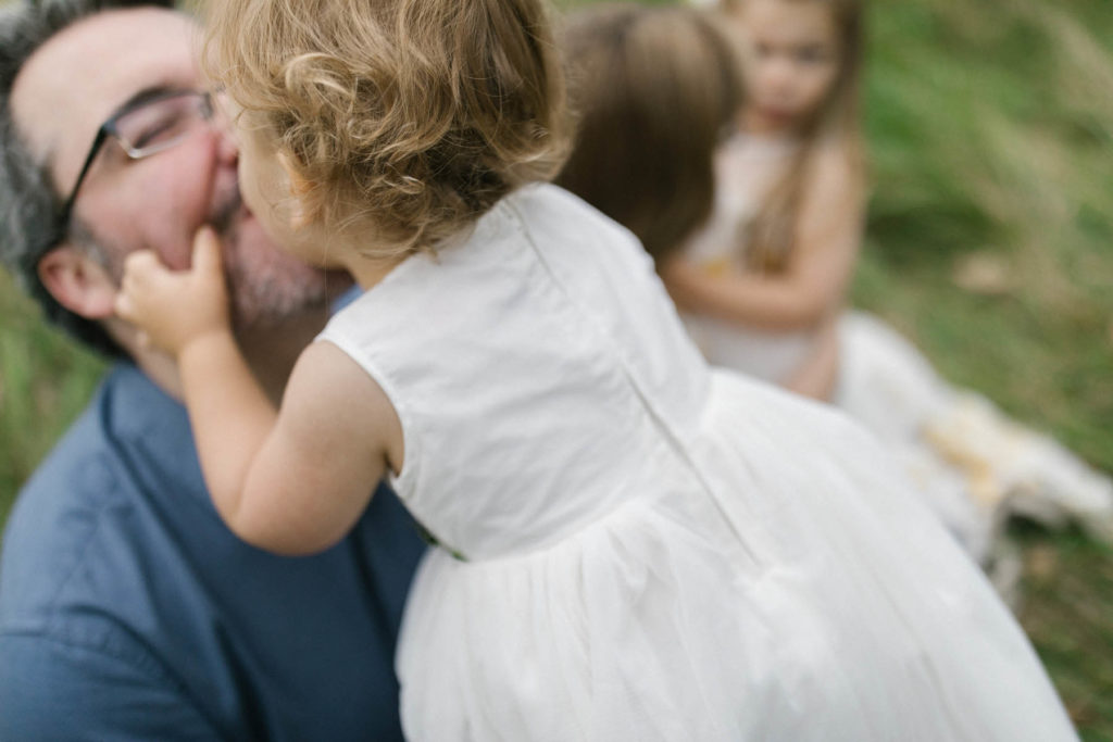 little girl kissing her dad 