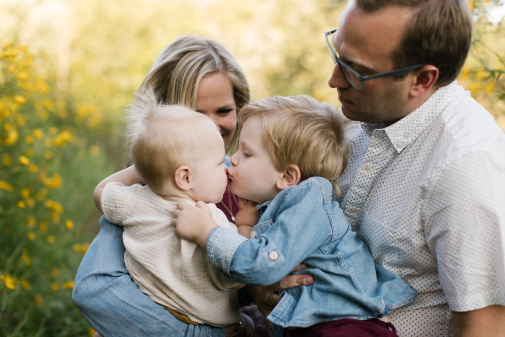 boy kissing his baby brother during fun family session