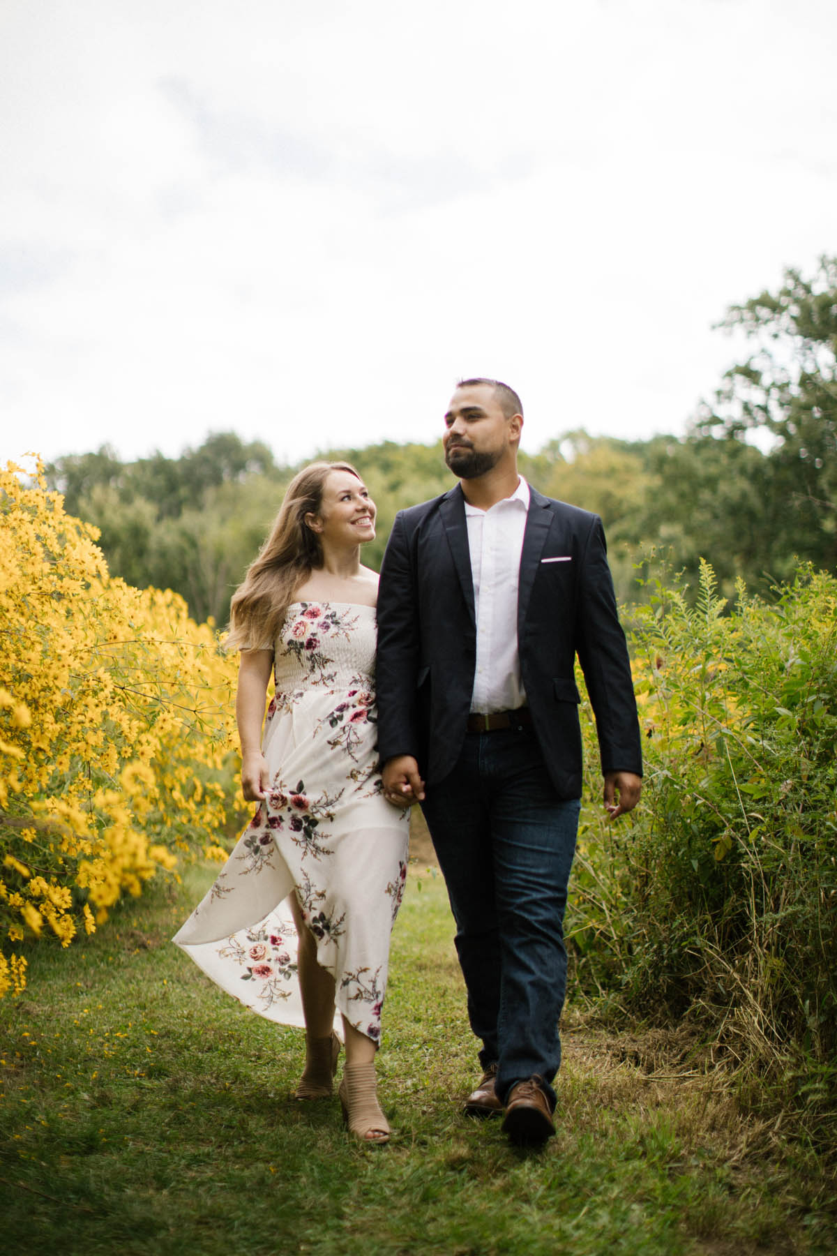 couple taking a walk after proposal during engagement photo shoot 