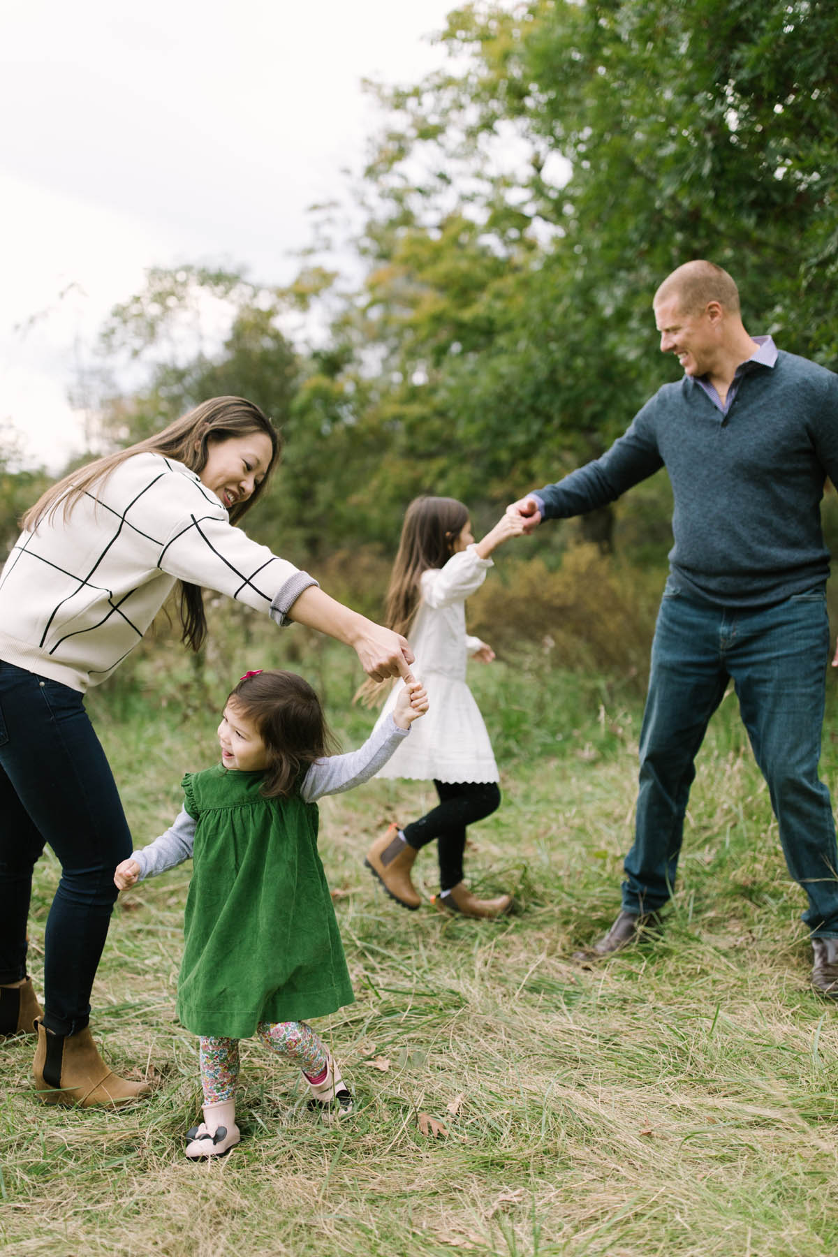 family of four dance in a field during a magical inspired photo shoot 