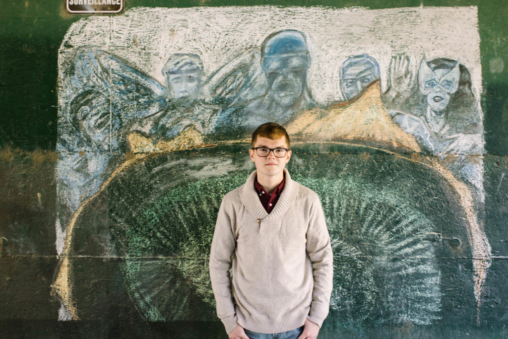 boy in front of chalk art during his senior photography session 