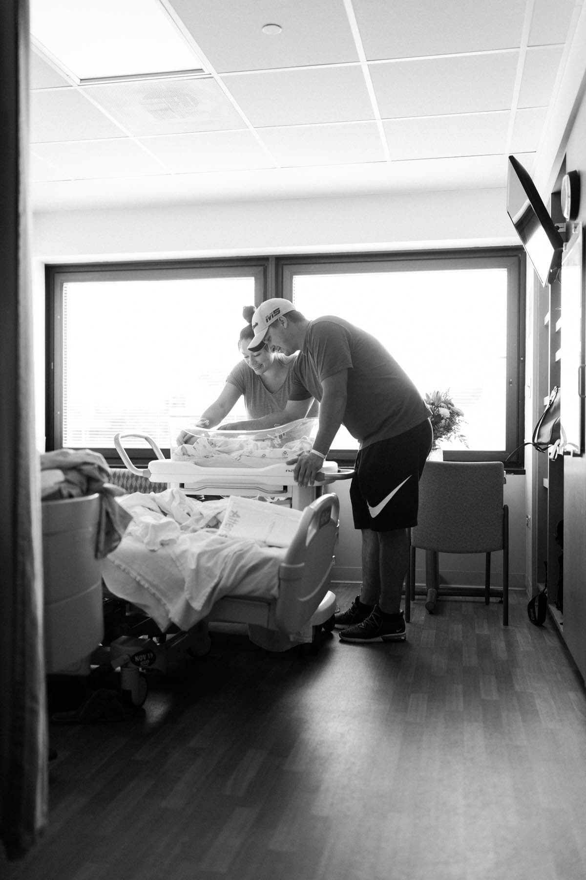 a peek inside of a hospital room where mom and dad are gazing at their newborn baby boy