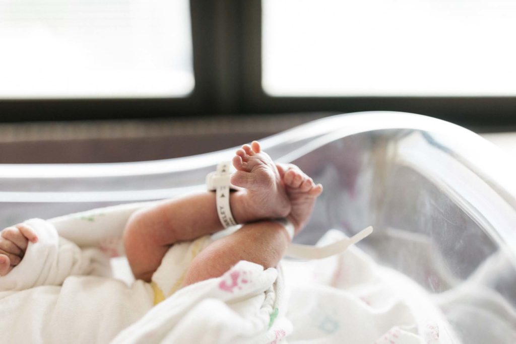 newborn baby boy's feet with hospital bracelet 