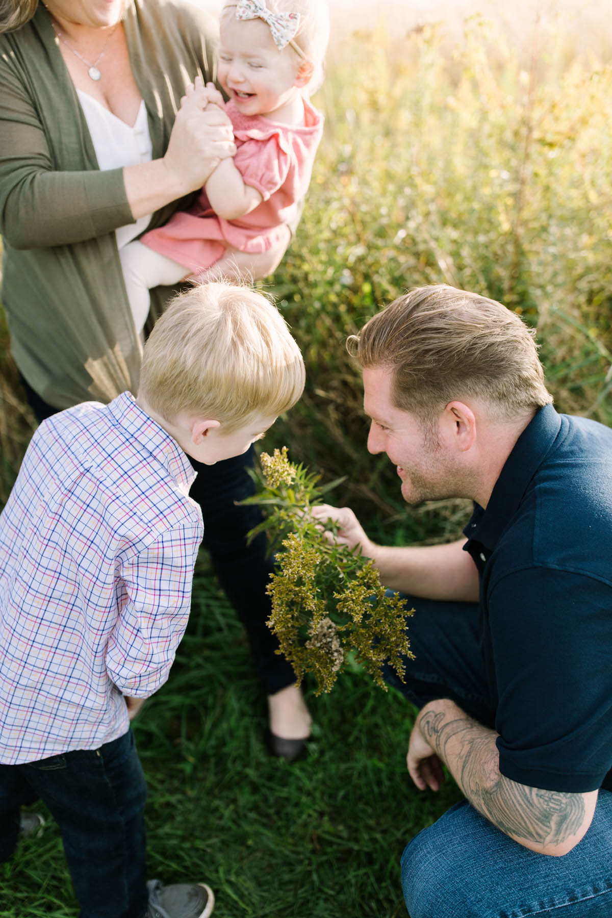 Little boy smells yellow flowers during family session 