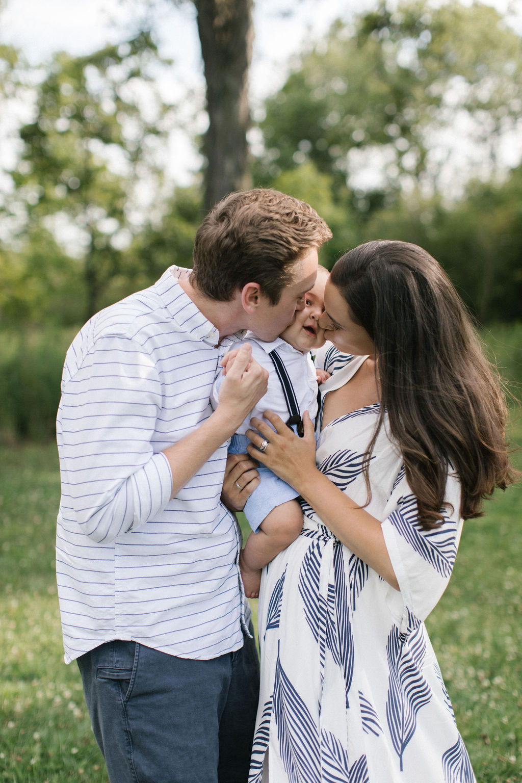family of three kissing and hugging during family session with Elle Baker Photography 
