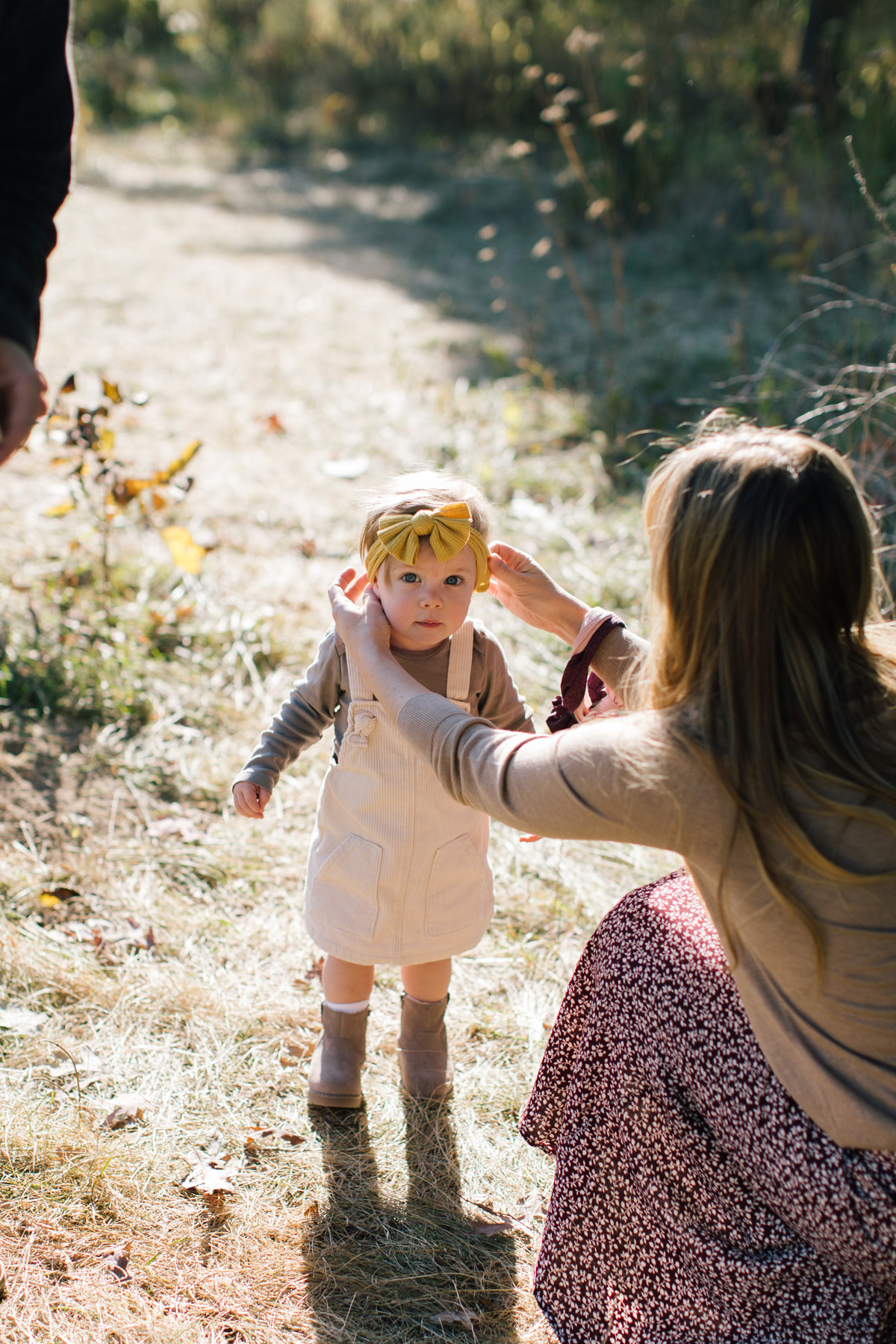 mom fixing daughters headband during session