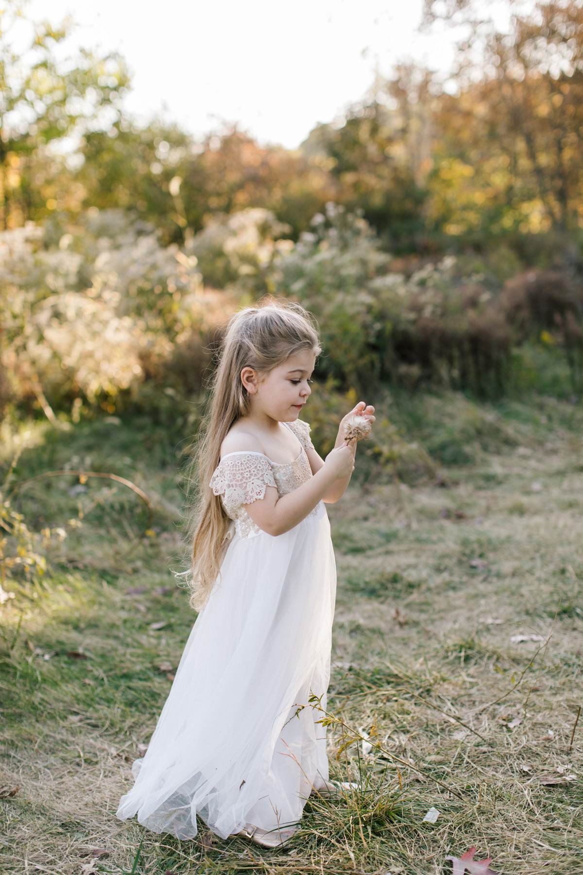 Little girl 'finding the light' and playing with a flower