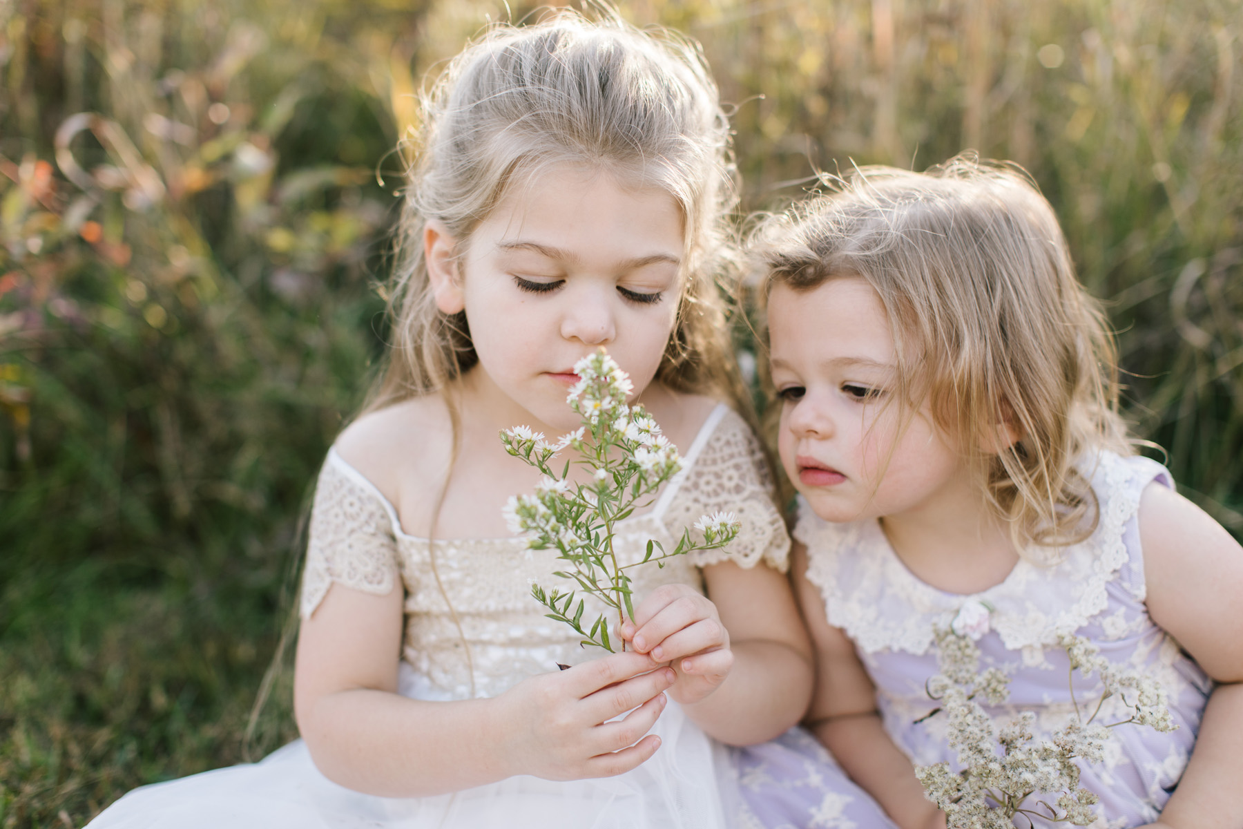 little girls smelling wildflowers 