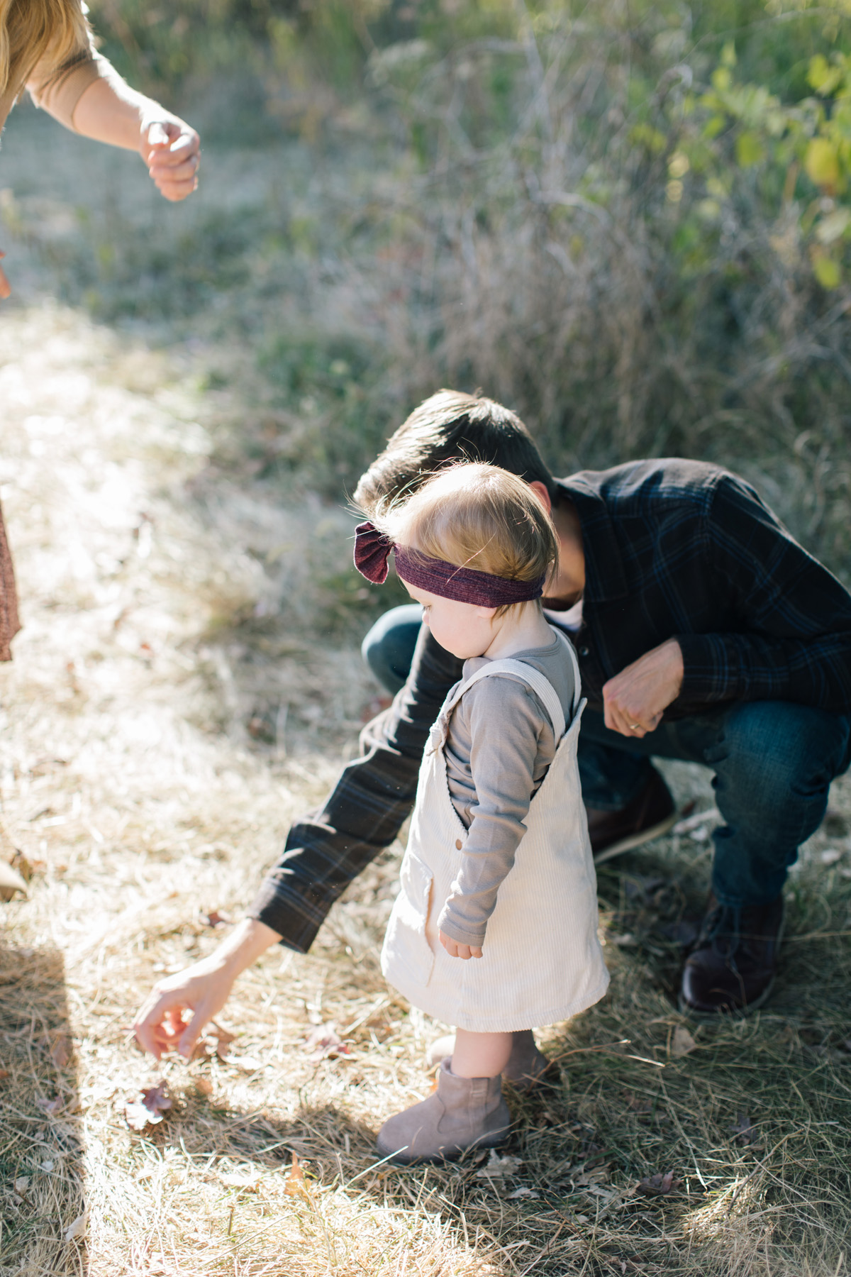 dad pointing to a leaf with daughter during fall family mini session