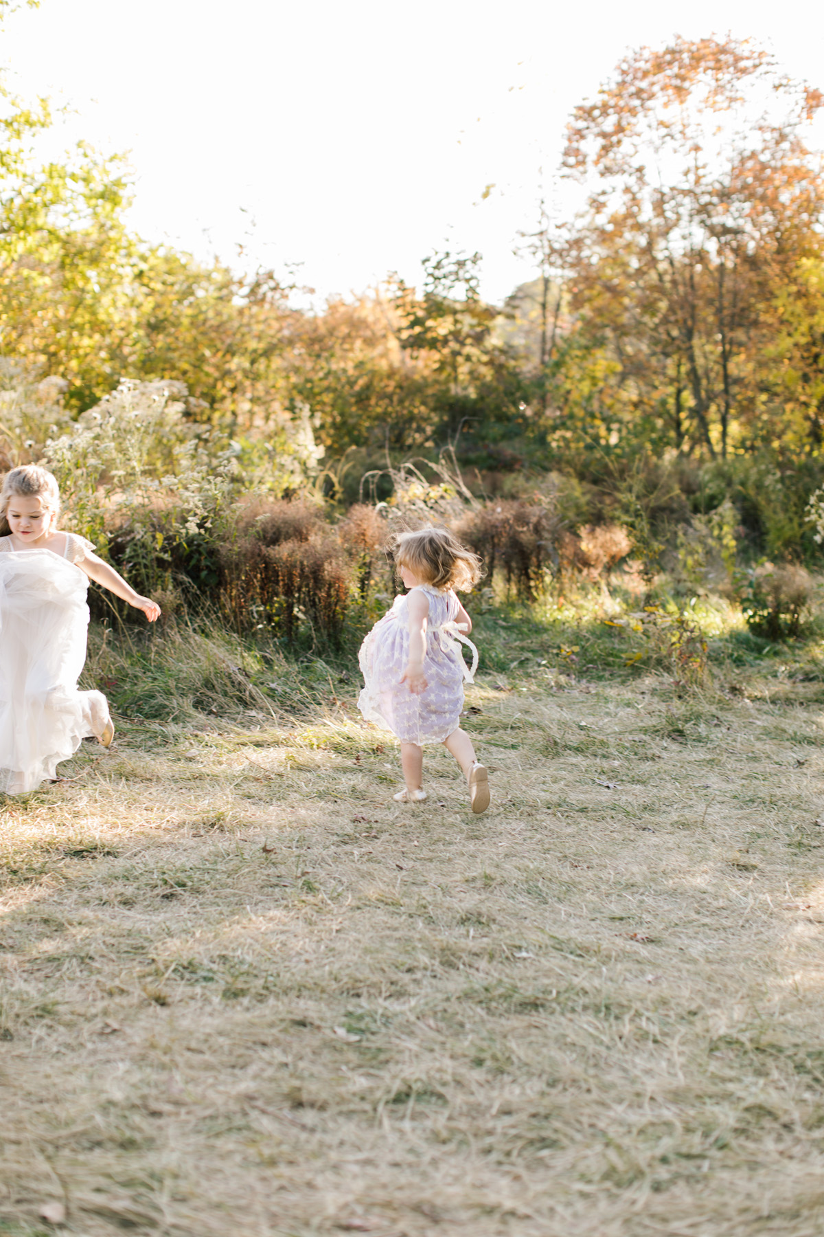 find the light through photography with two young girls dancing in a forest preserve 