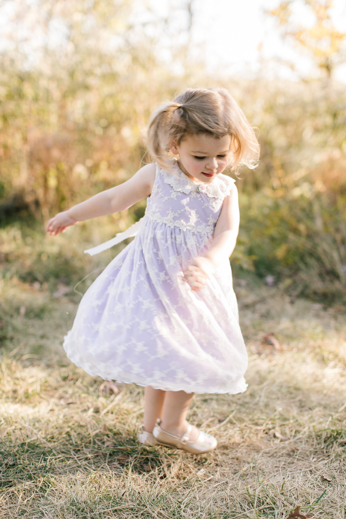 lilac dress and a little girl twirling during photo session 
