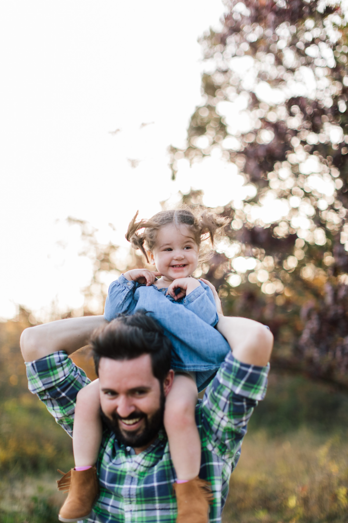 little girl on her dad's shoulders during family mini session 