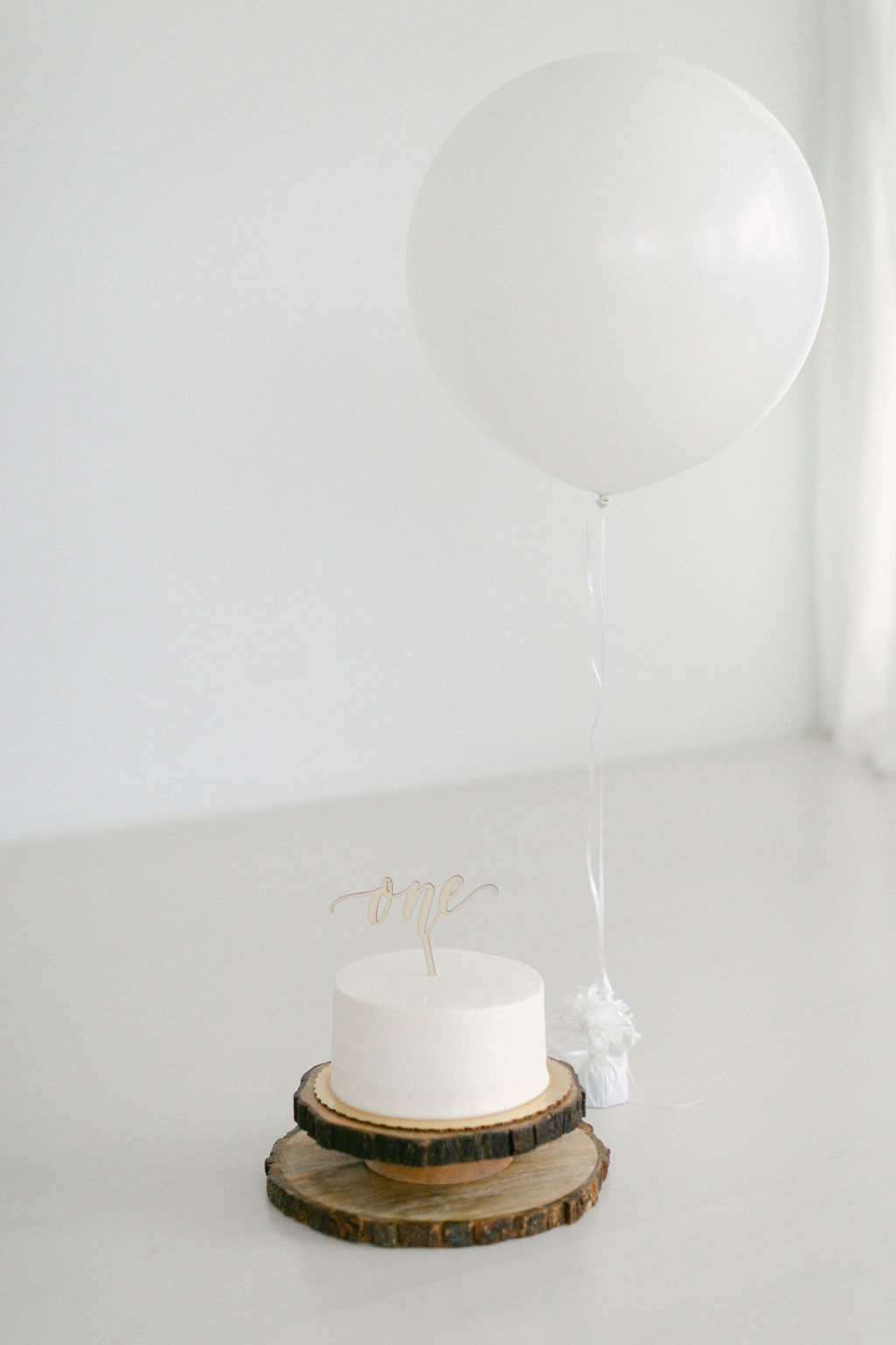 white cake and simple white set up for birthday party 