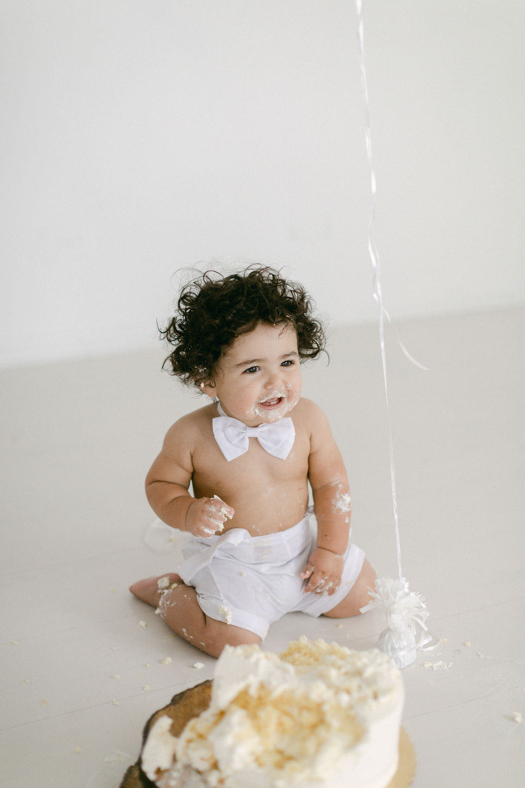 baby in white shorts and white tie in Chicago photography studio