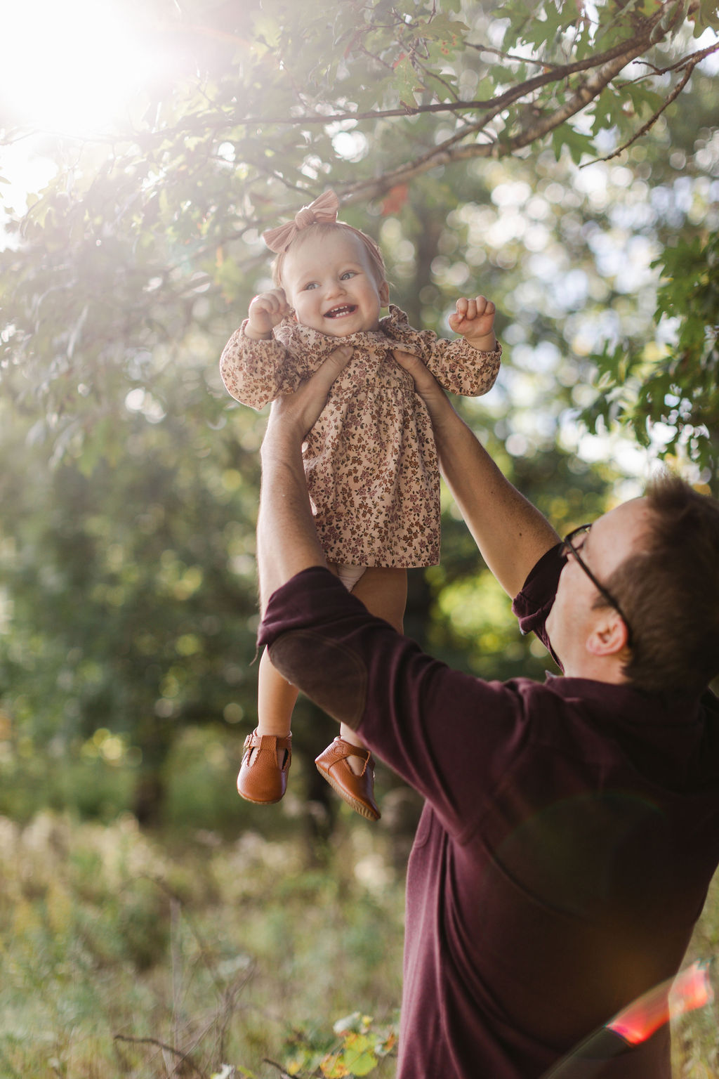 dad holding baby girl up into the air